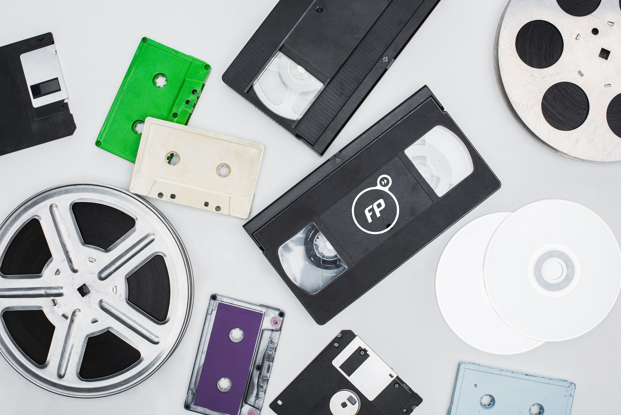 Flat Lay Of Vhs Cassettes Diskettes Cd Discs Film Reels And Colorful Cassettes On White Background
